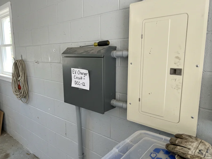 Mounted DCC-12 load management enclosure beside the panel