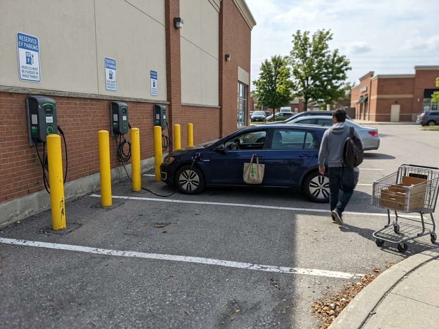 Row of networked Level 2 chargers in a retail parking lot